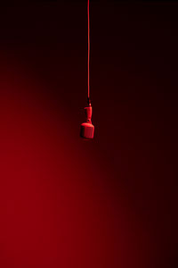 a red light bulb hanging from a red cord