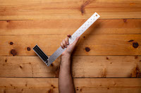 Arm holding joiner s square on light wooden background - Labor Day